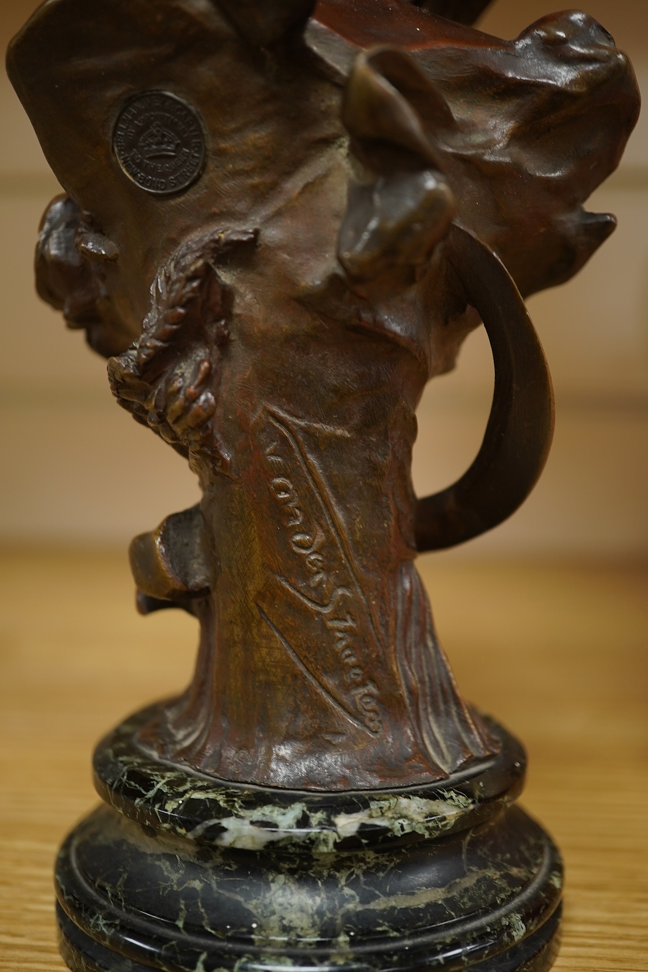 A late 19th century bronze bust of a lady in a hat with floral decoration , mounted on marble, signed, 21.5cm high.